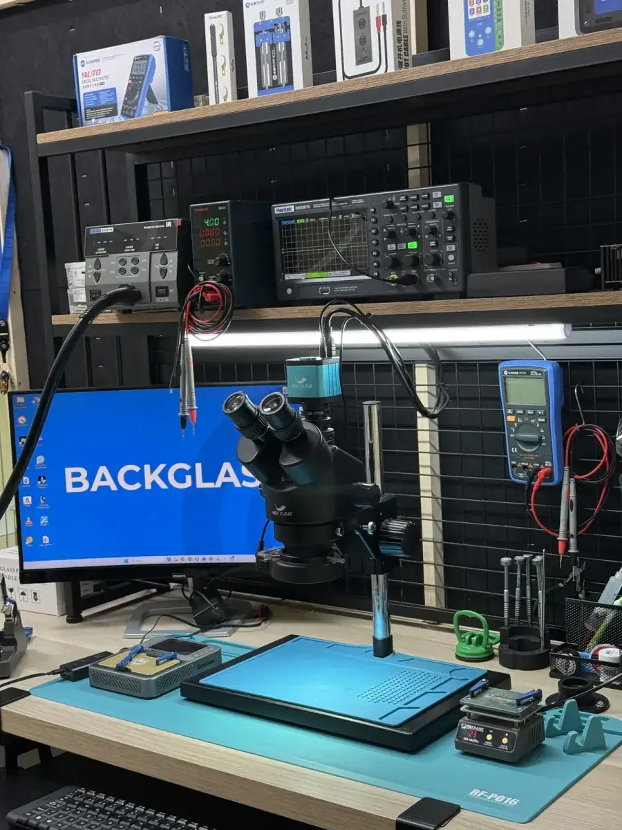 Fran Azzali trabajando en el laboratorio de microsoldadura de BACKGLASS Almería con microscopio y estación de reparación